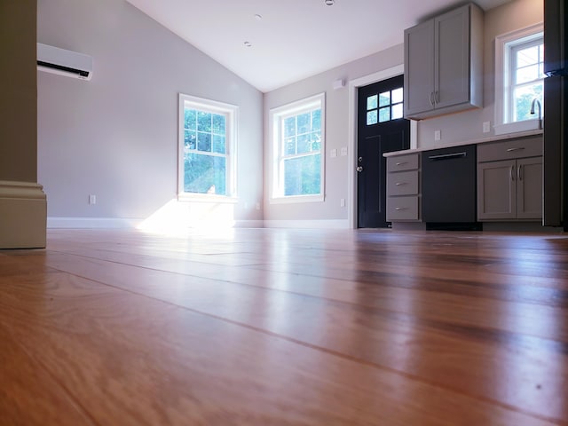 kitchen with a wall mounted AC, dishwasher, vaulted ceiling, dark hardwood / wood-style flooring, and gray cabinets