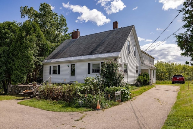 view of property exterior featuring a shingled roof and a chimney