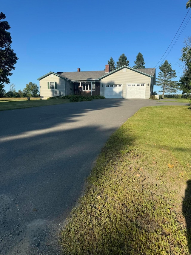 ranch-style home with a garage and a front lawn