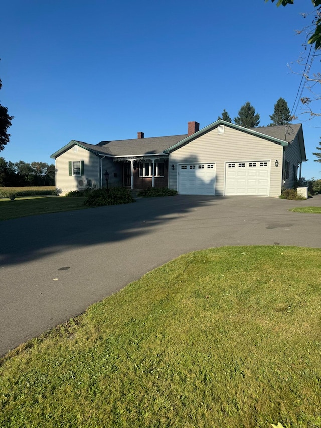 single story home featuring a garage and a front yard