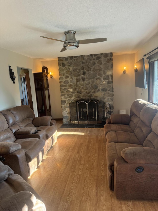 265 Main Rd, Bradford, ME 04410 - living room with a textured ceiling, a fireplace, and wood finished floors