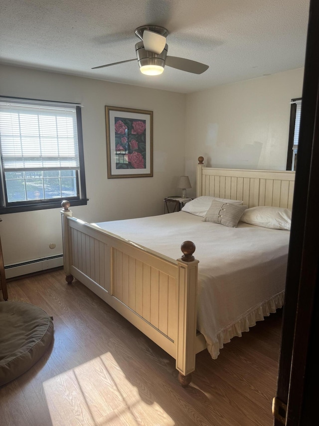 265 Main Rd, Bradford, ME 04410 - bedroom with a ceiling fan, a baseboard radiator, a textured ceiling, and wood finished floors