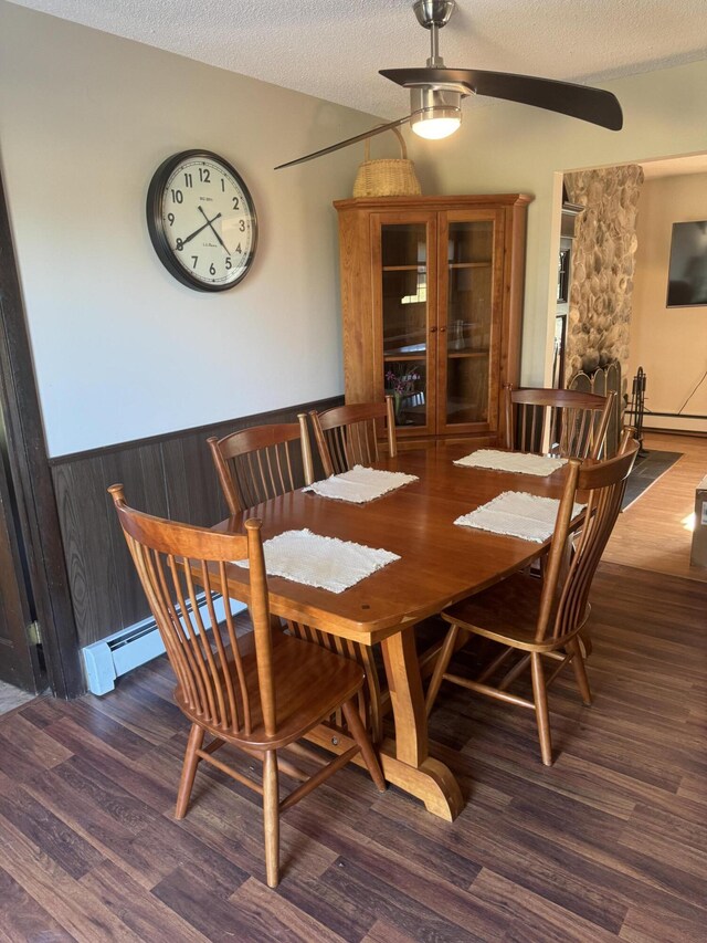 265 Main Rd, Bradford, ME 04410 - dining room featuring wainscoting, a baseboard radiator, ceiling fan, wood finished floors, and a textured ceiling
