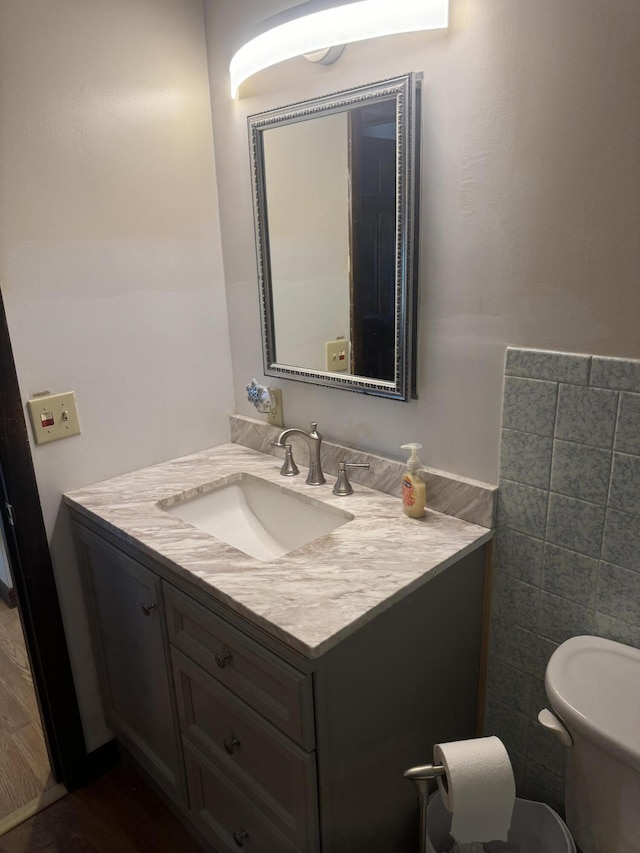 265 Main Rd, Bradford, ME 04410 - half bathroom with toilet, wood finished floors, vanity, and tile walls