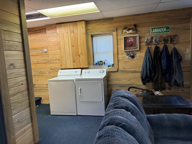 washroom with washer and dryer, wooden walls, and carpet floors