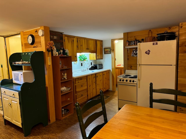 kitchen with white appliances, sink, and dark hardwood / wood-style floors