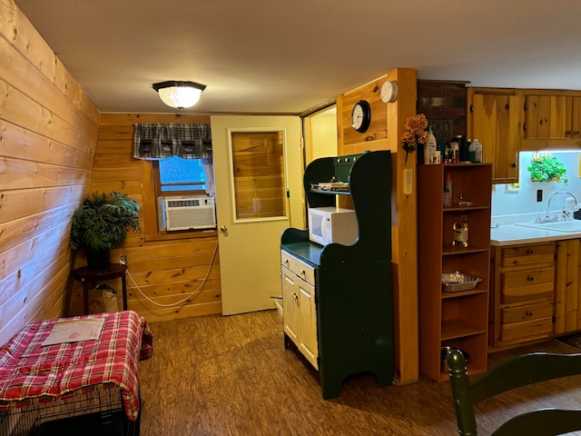 kitchen featuring cooling unit, wood walls, sink, and hardwood / wood-style flooring