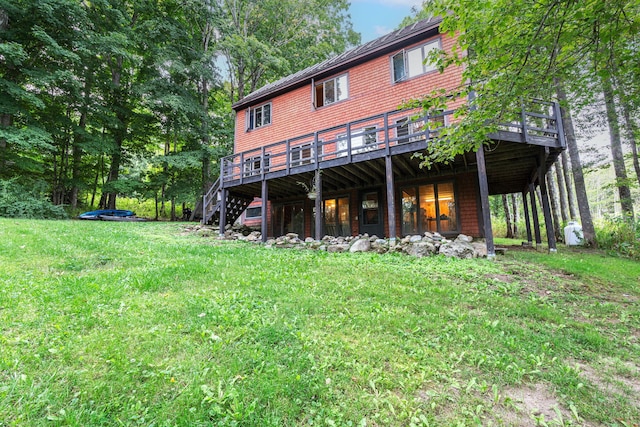 rear view of property featuring a lawn and a wooden deck