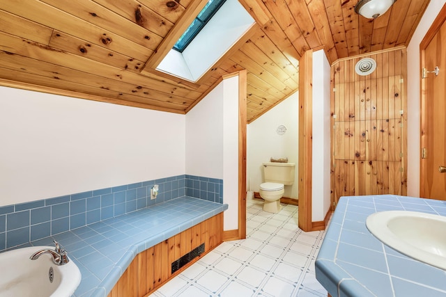 bathroom with toilet, a bathing tub, sink, and wooden ceiling