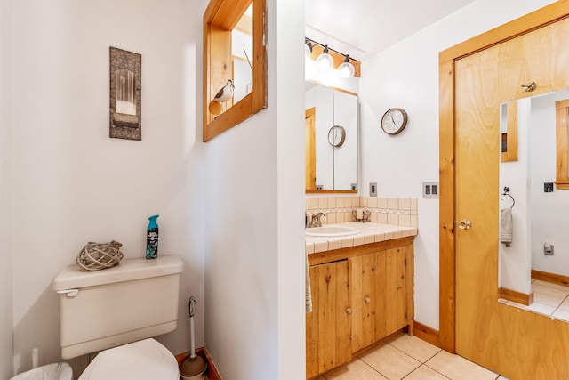 bathroom with vanity, toilet, tasteful backsplash, and tile patterned floors