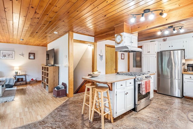 kitchen with white cabinetry, stainless steel appliances, a kitchen breakfast bar, wood-type flooring, and a kitchen island