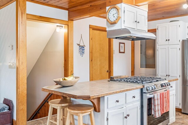 39 Simmons Ln, Friendship, ME 04547 - kitchen featuring white cabinetry, under cabinet range hood, appliances with stainless steel finishes, and wood ceiling