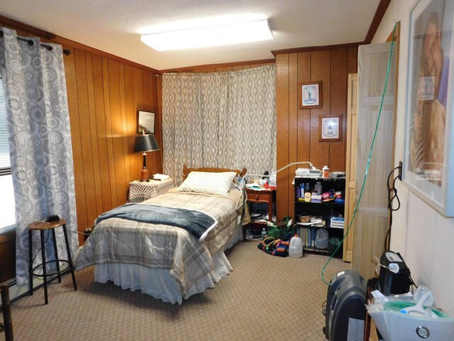 bedroom with ornamental molding, wood walls, and carpet