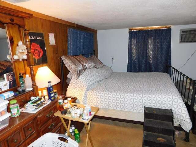 bedroom with a wall unit AC, wooden walls, carpet floors, and a textured ceiling