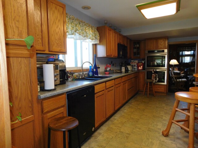 kitchen featuring dishwasher, sink, and double oven