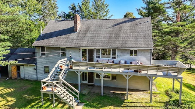 rear view of property featuring a yard and a wooden deck