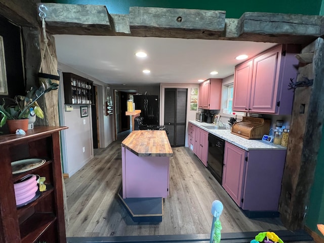 kitchen with blue cabinets, black appliances, butcher block countertops, and light hardwood / wood-style floors