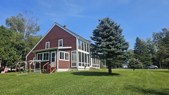 view of home's exterior featuring a yard and a sunroom