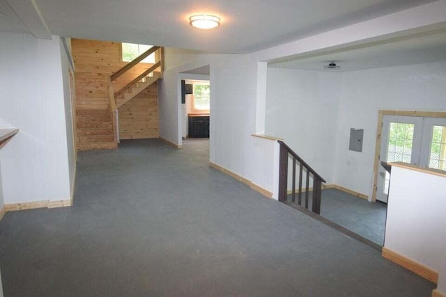 hall featuring carpet floors and wooden walls