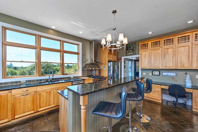 kitchen with built in desk, appliances with stainless steel finishes, a chandelier, a kitchen island, and tasteful backsplash