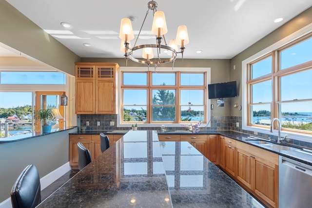 kitchen featuring a healthy amount of sunlight, a notable chandelier, sink, and dishwasher