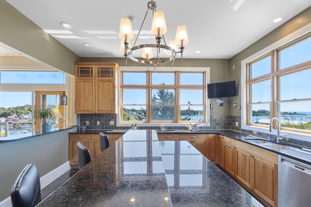 kitchen with a notable chandelier, a sink, granite finish floor, stainless steel dishwasher, and decorative backsplash