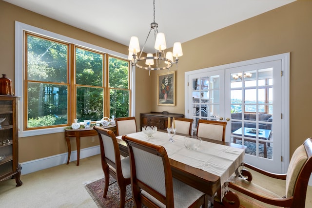 dining space featuring light colored carpet and a chandelier