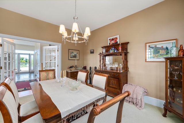 dining space with carpet flooring and a chandelier