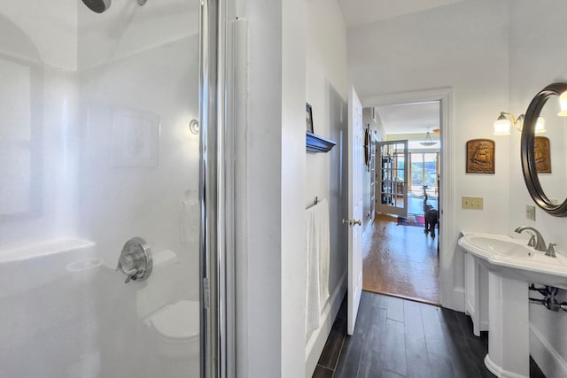 bathroom featuring french doors, walk in shower, and hardwood / wood-style flooring