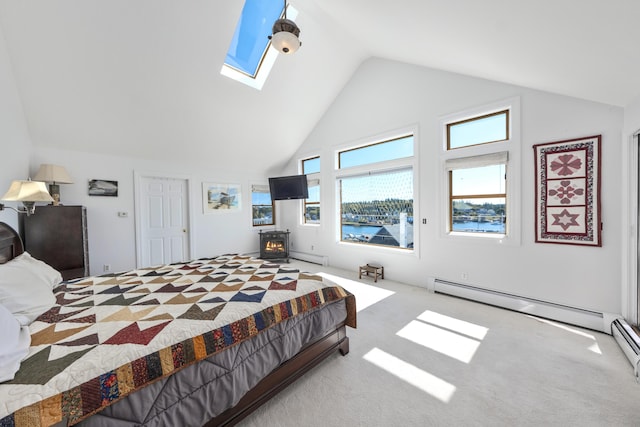 carpeted bedroom with baseboard heating, high vaulted ceiling, a skylight, and a wood stove