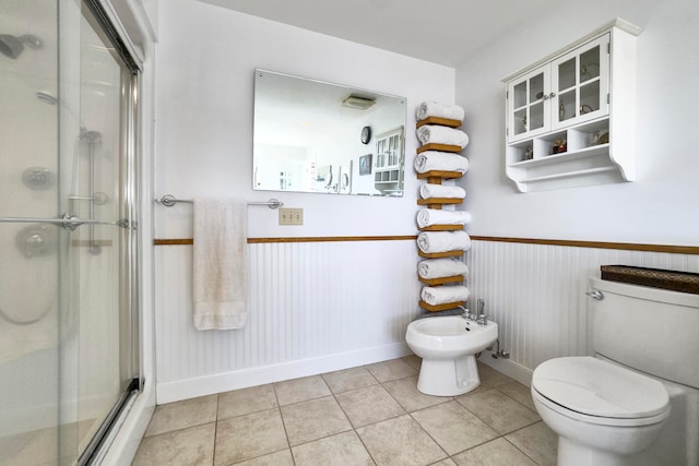 bathroom with a bidet, toilet, tile patterned floors, and walk in shower