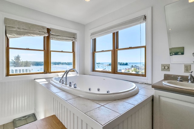 bathroom with a wealth of natural light, vanity, a water view, and a washtub