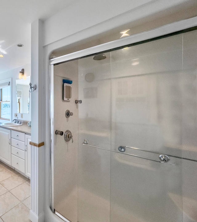 bathroom featuring tile patterned floors, an enclosed shower, and vanity