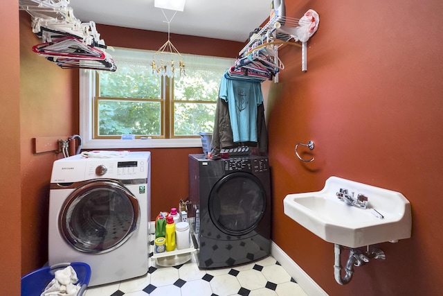 laundry area featuring tile patterned floors, laundry area, a sink, and independent washer and dryer