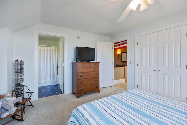 carpeted bedroom featuring a closet, ceiling fan, ensuite bathroom, and vaulted ceiling