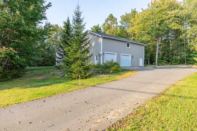 view of property exterior featuring a yard and a garage