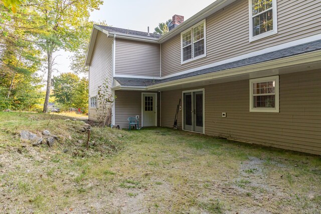 rear view of property featuring a lawn