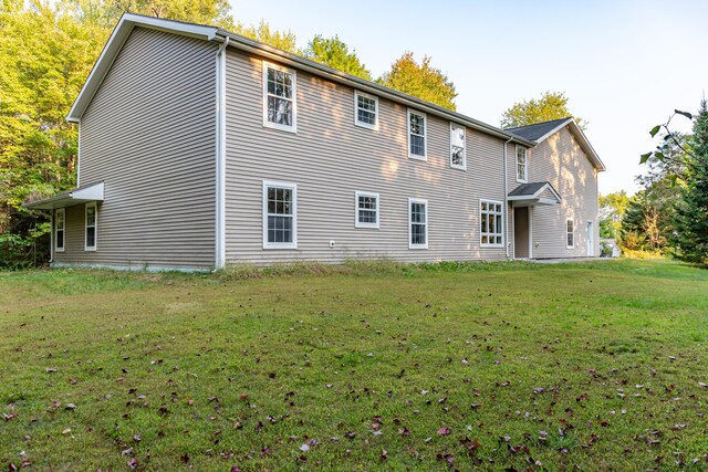 rear view of house featuring a yard