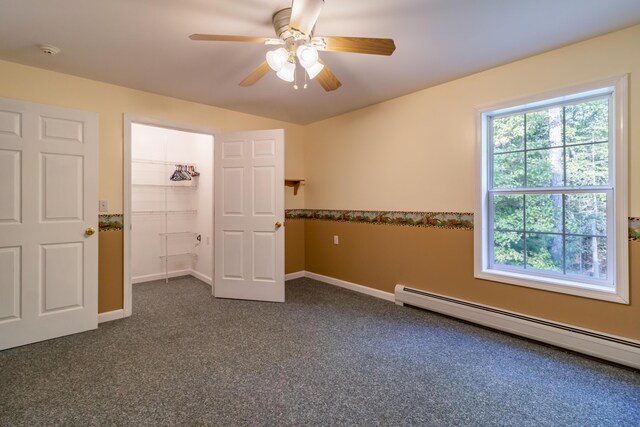 unfurnished bedroom with baseboard heating, dark carpet, a closet, and ceiling fan