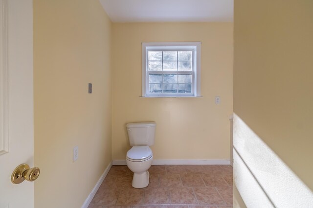 bathroom featuring toilet and tile patterned flooring