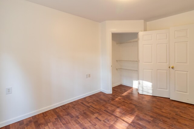 unfurnished bedroom featuring dark wood-type flooring and a closet