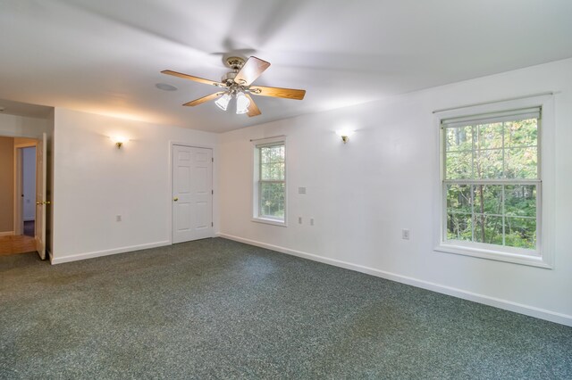 carpeted empty room featuring ceiling fan and a wealth of natural light