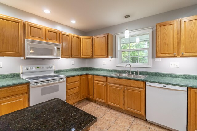 kitchen with white appliances, light tile patterned floors, sink, and decorative light fixtures