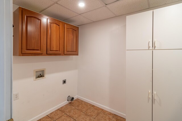 clothes washing area featuring hookup for a washing machine, electric dryer hookup, light tile patterned floors, and cabinets