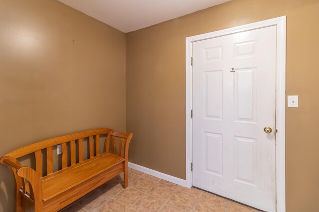 interior space with light tile patterned flooring and a crib