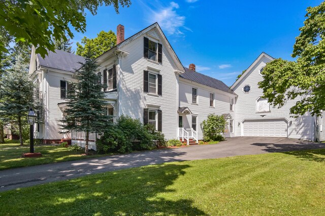 view of front of property featuring a garage and a front lawn