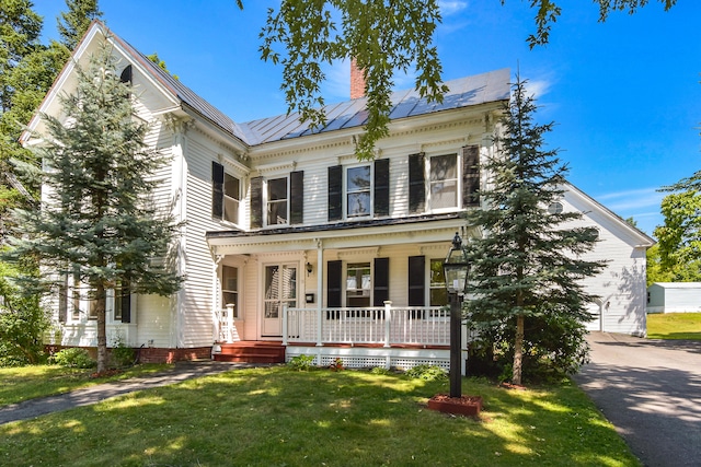 view of front facade with covered porch and a front yard