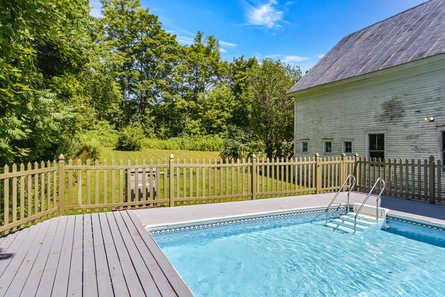 view of swimming pool with a yard and a deck