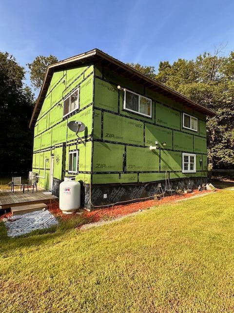 view of side of home with a yard and a wooden deck