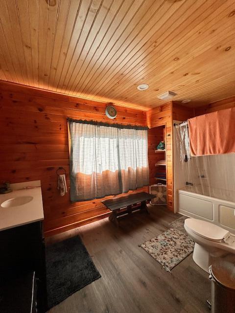 full bath featuring wooden walls, a shower with shower curtain, toilet, wooden ceiling, and wood finished floors